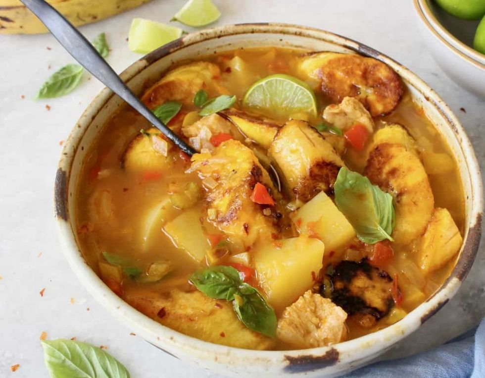 A bowl of soup has a spoon in it.