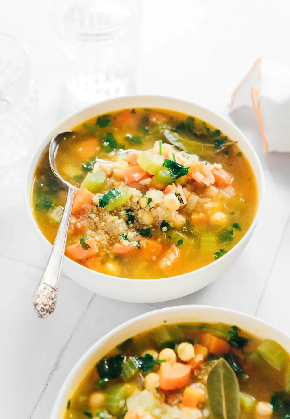 A bowl of soup has a spoon in it.