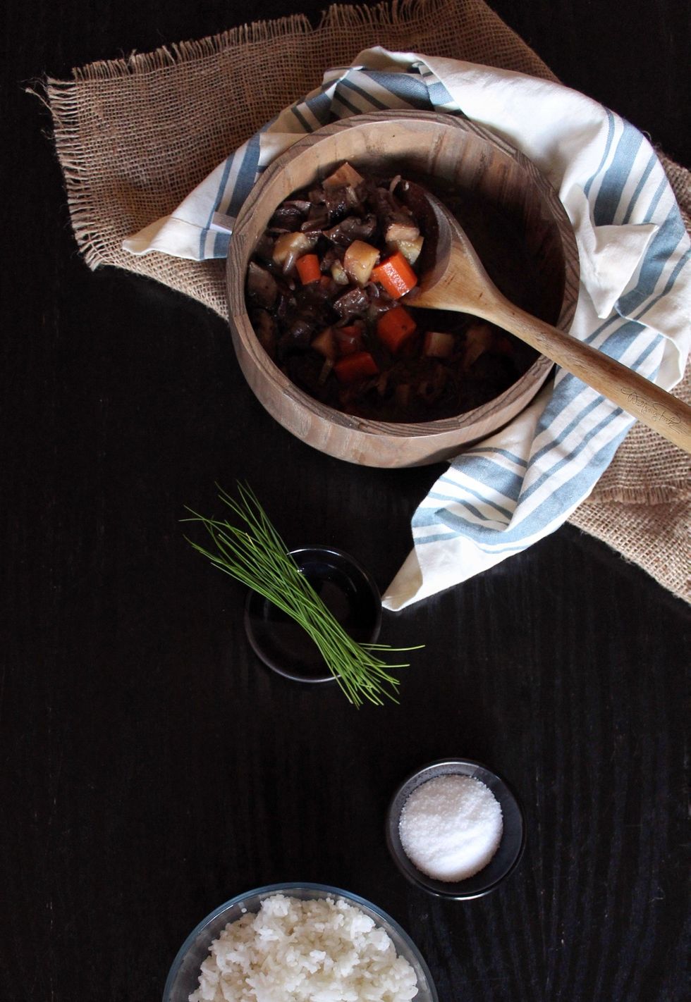 A bowl of soup sits next to its ingredients.