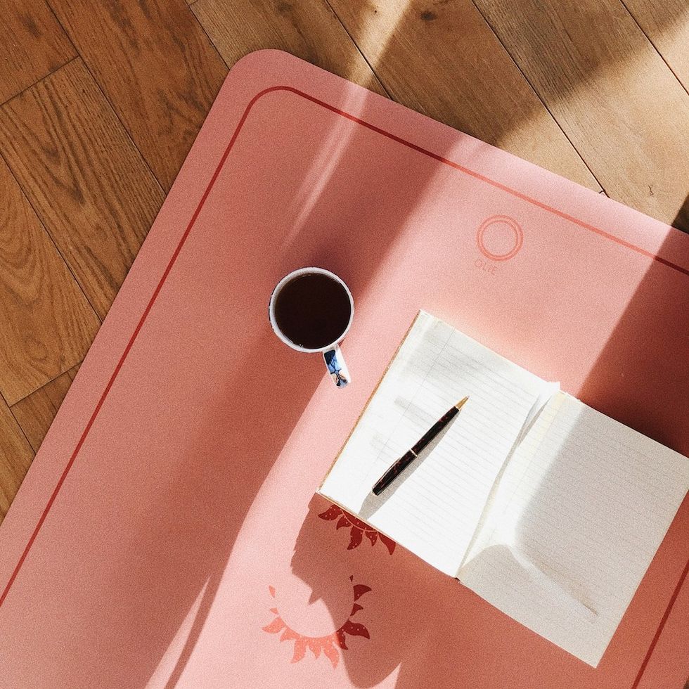 a journal and a cup of coffee on a yoga mat