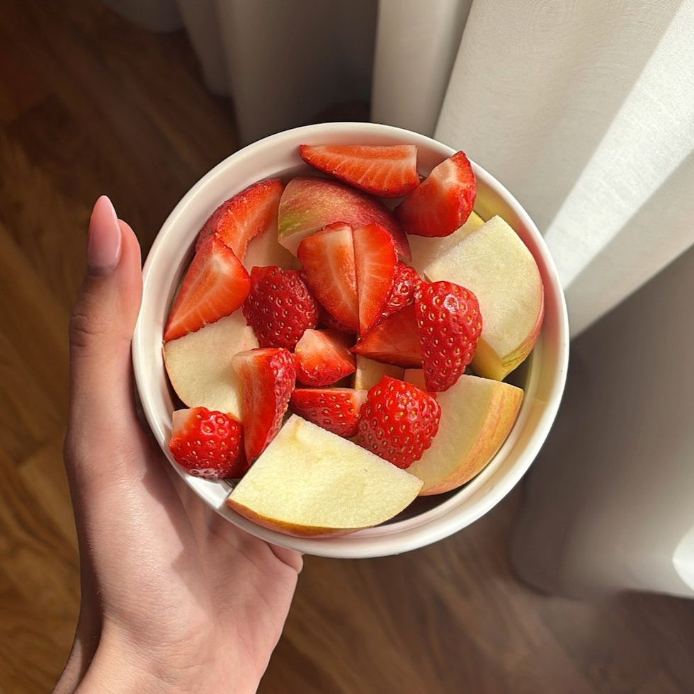 a woman holding a fruit bowl