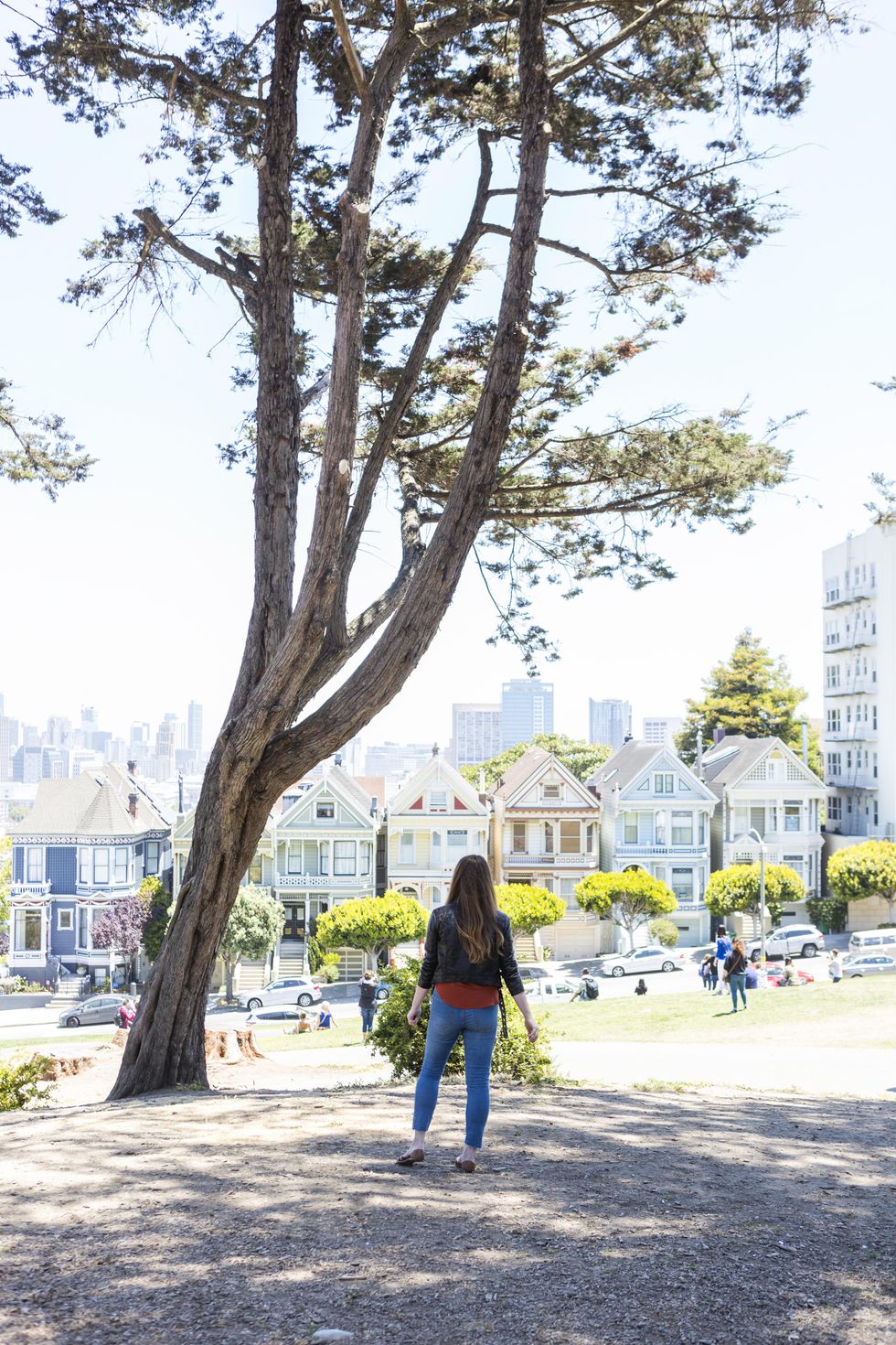 a woman looks at the row houses in san fransisco