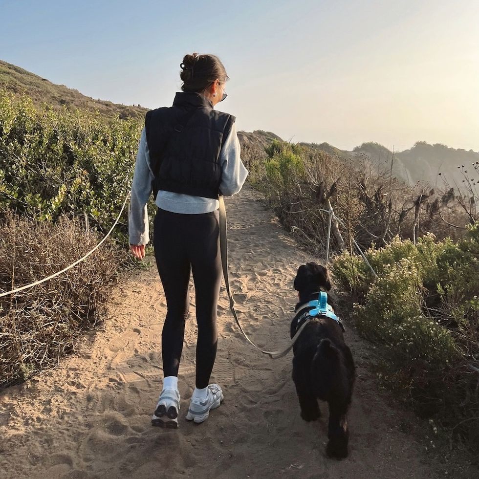 a woman walking her dog down a path