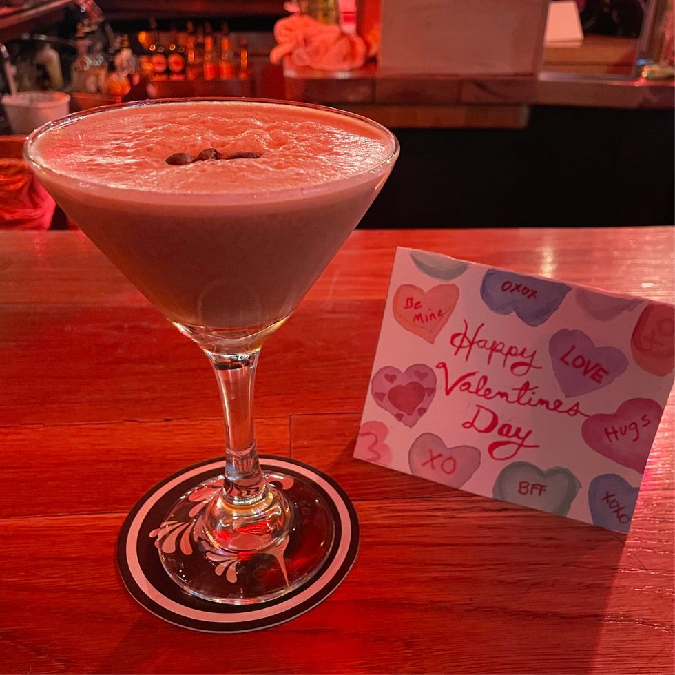 an espresso martini next to a valentine's day card