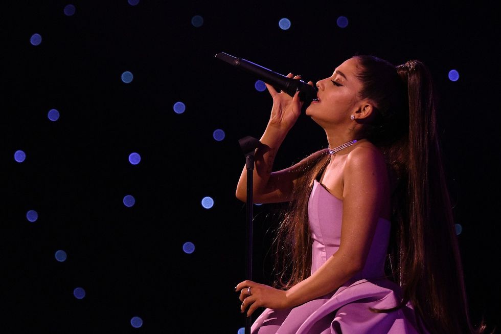 ariana grande singing onstage in a pink dress