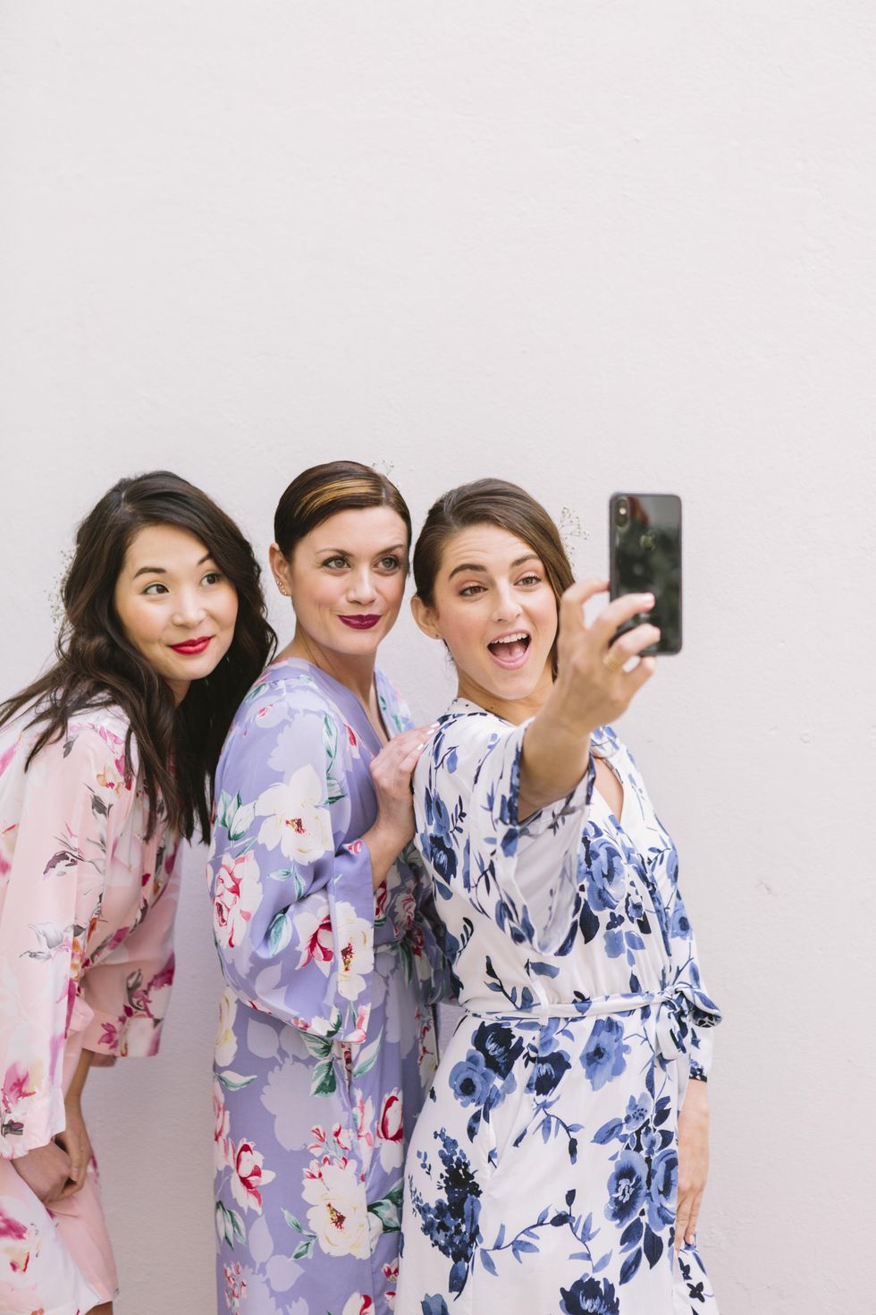 bridesmaids taking a selfie in their floral robes