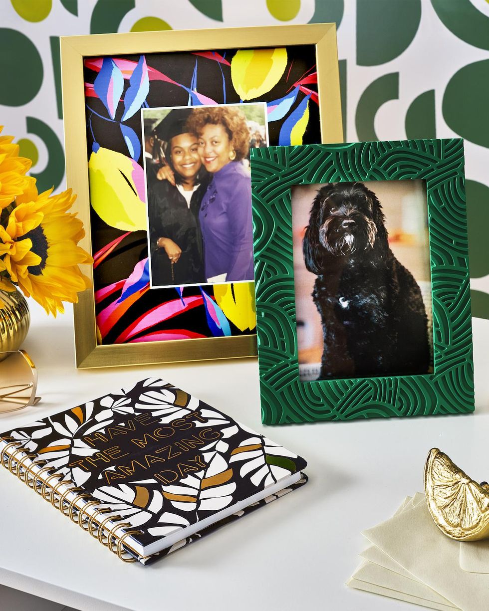 colorful picture frames, golden lemon, and have the most amazing day notebook on a white desk