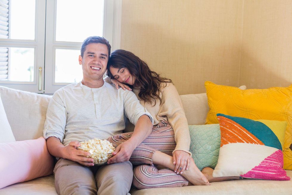 couple cuddling on couch eating popcorn