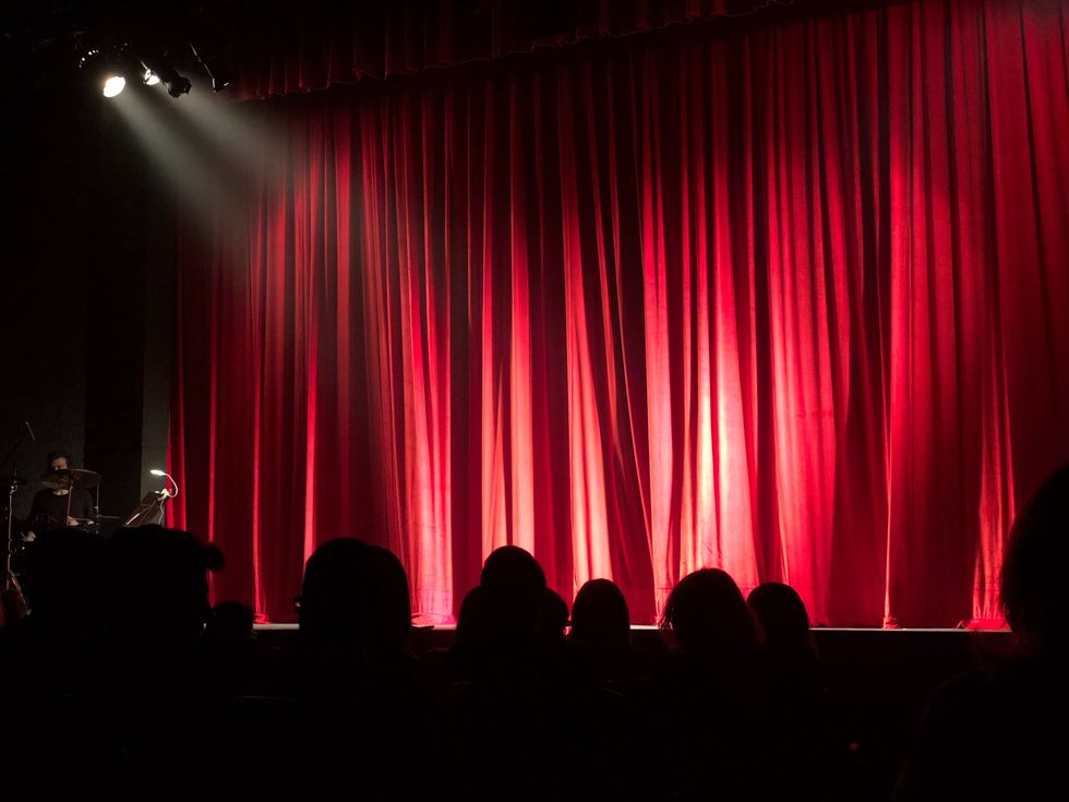 crowd looking at a red curtain