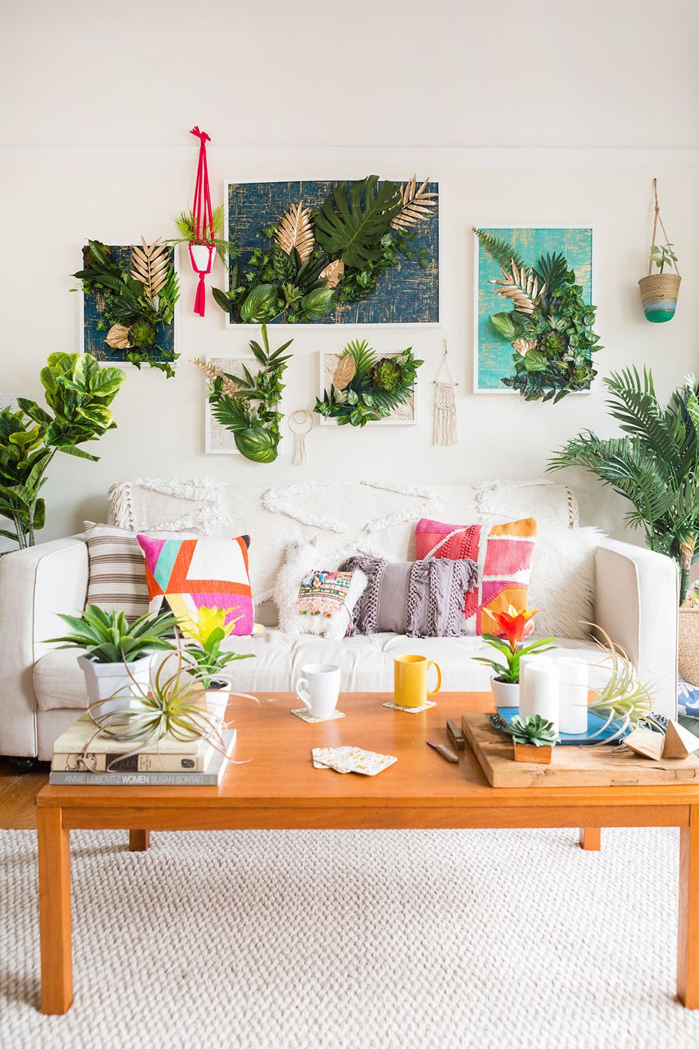 white living room with colorful art, rainbow throw pillows, and plants on the walls