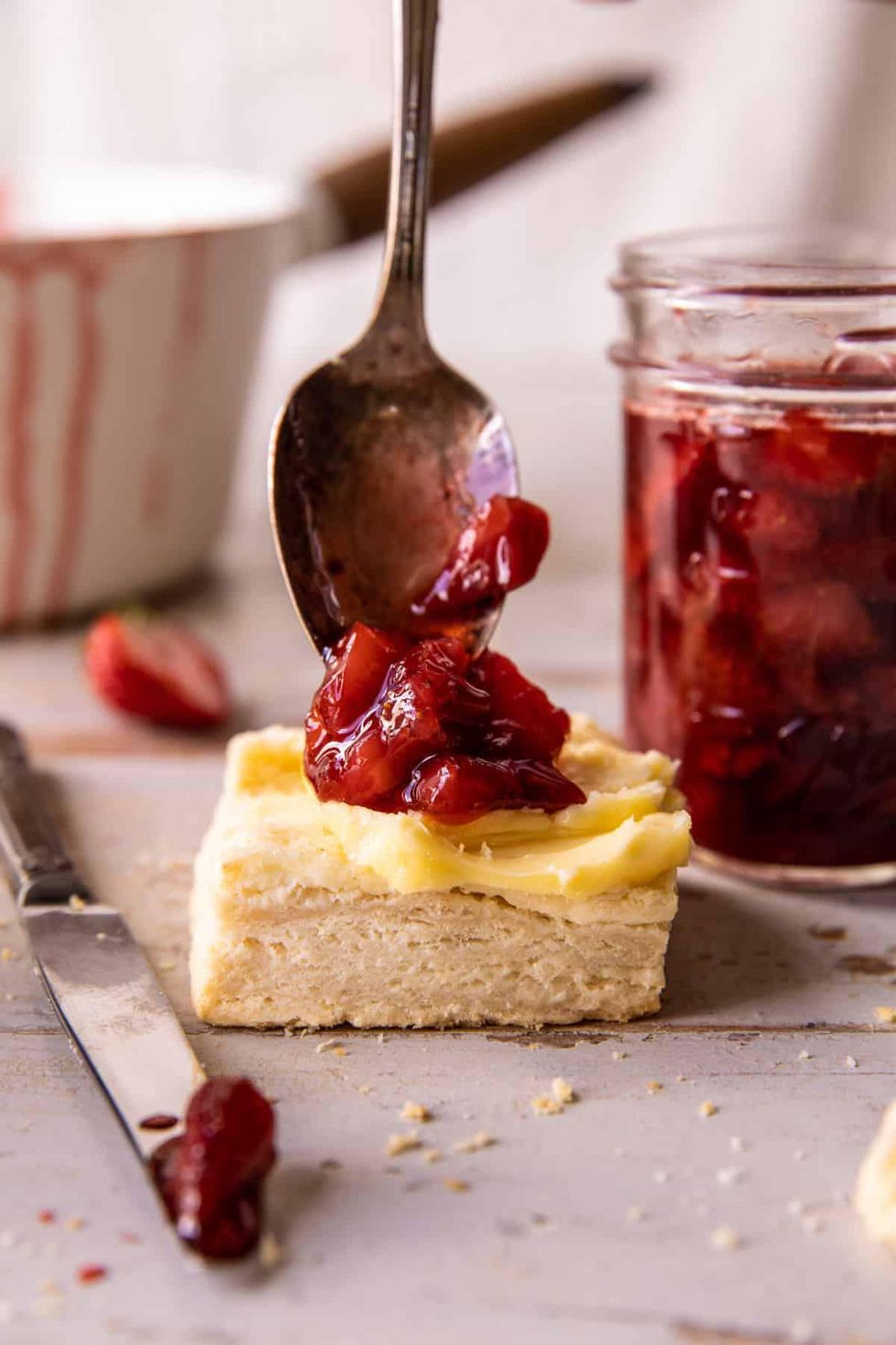 Placing the jam and butter on the biscuit