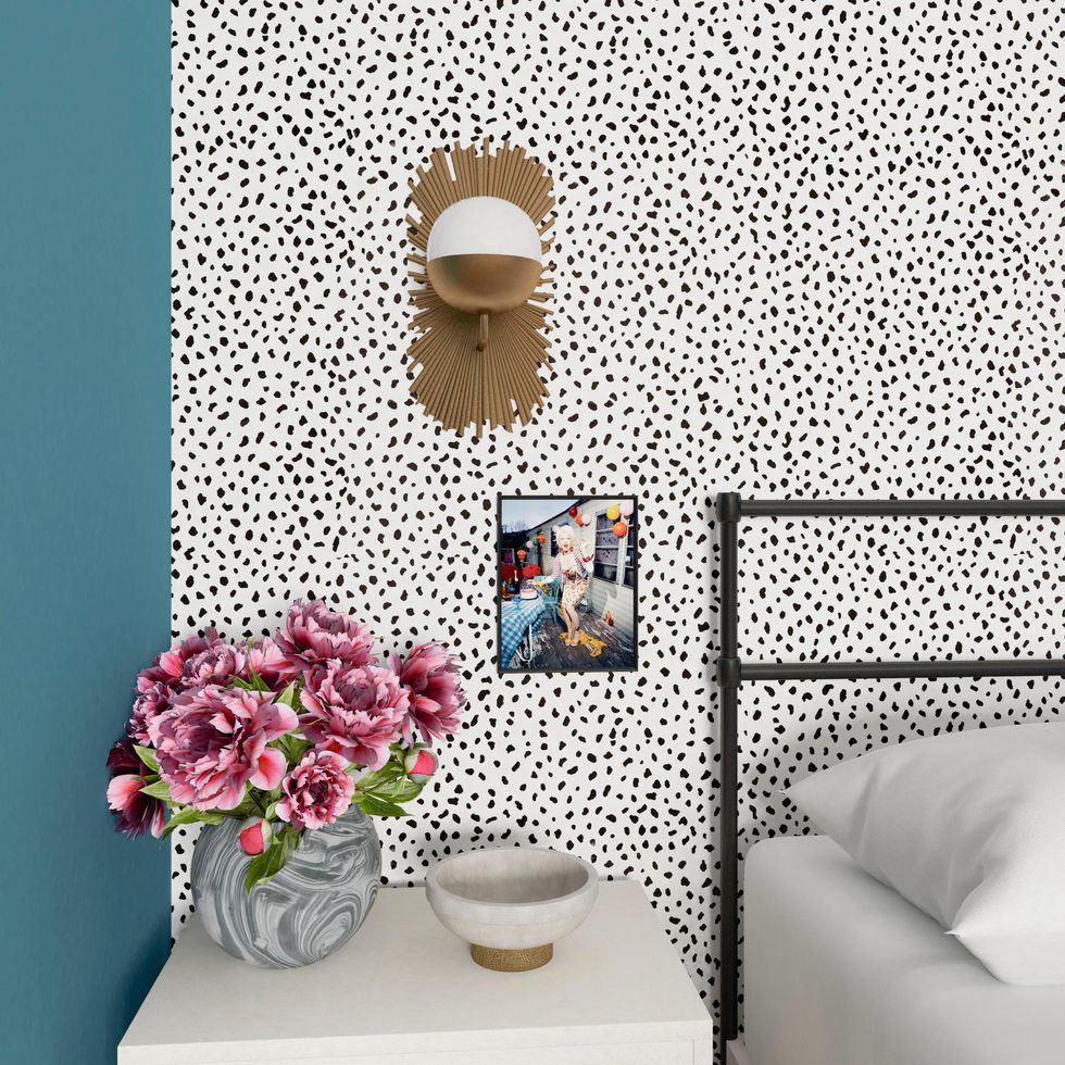 dorota and vanya apartment with photo of cindy lauper and pink flowers against a black and white dotted wall