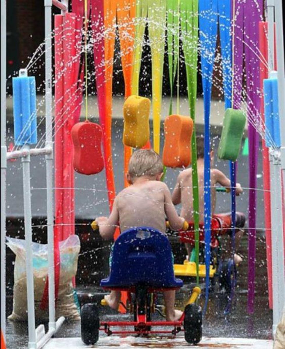 rainbow tricycle car wash with streamers, water, and sponges