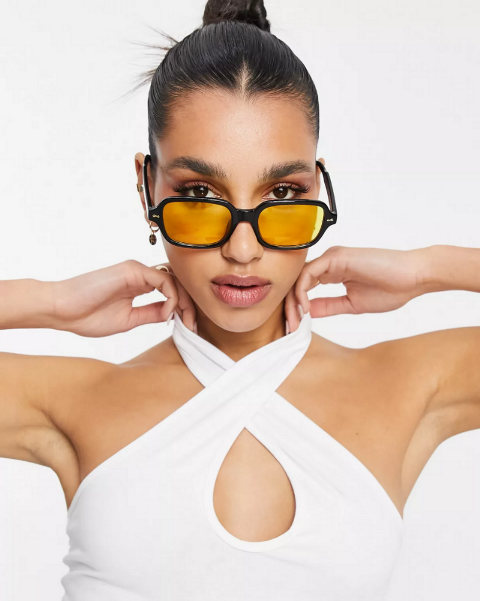 model wears yellow and black glasses with white top