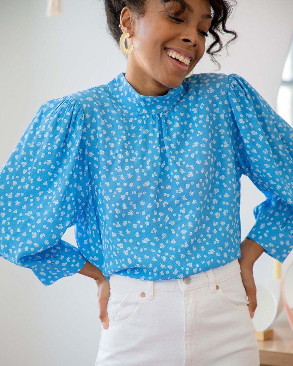 blue blouse with white daisies and puffed sleeves