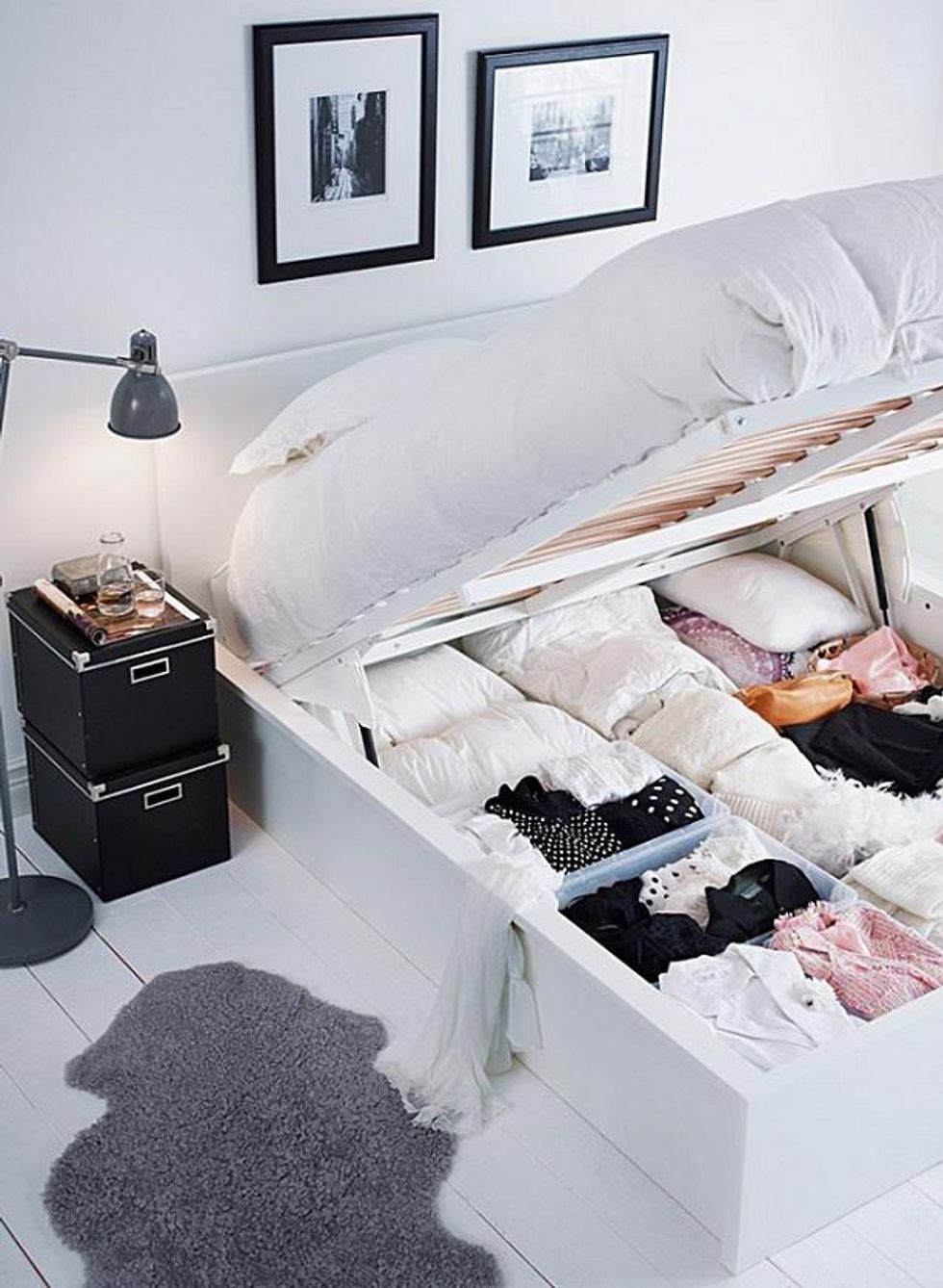 white bed frame with room for clothes underneath in a gray and white bedroom