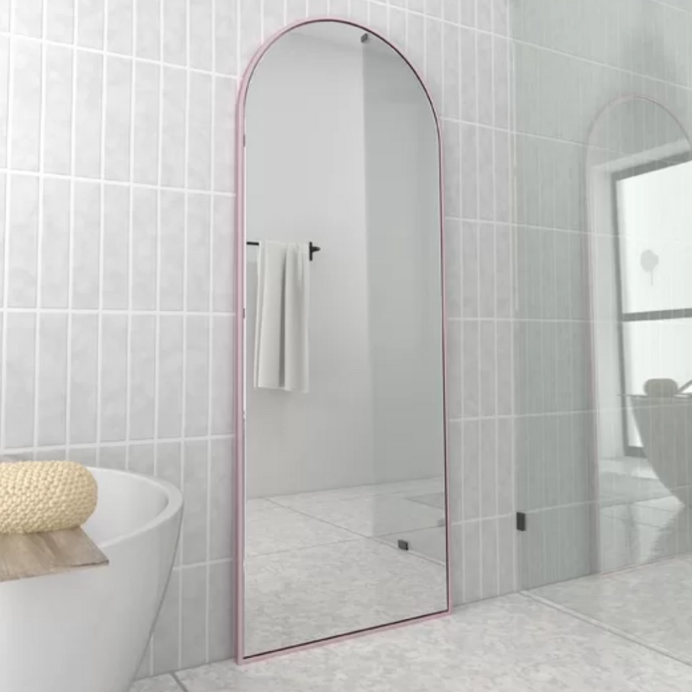 \u200bGlass Warehouse Kira Arch Full-Length Mirror with pink frame standing in a bathroom