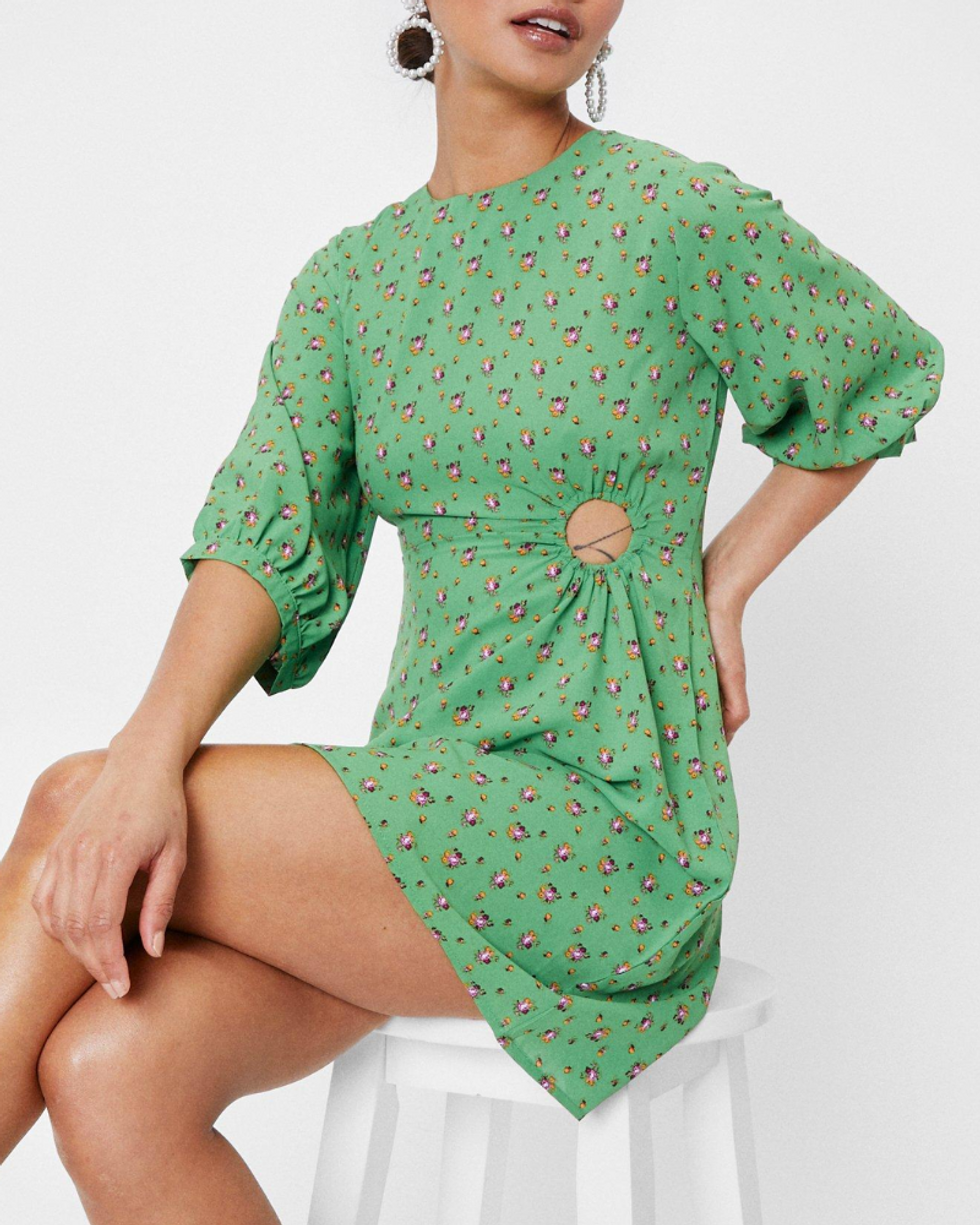 model wears green floral short dress with a cutout in the side and puffed 3/4 sleeve