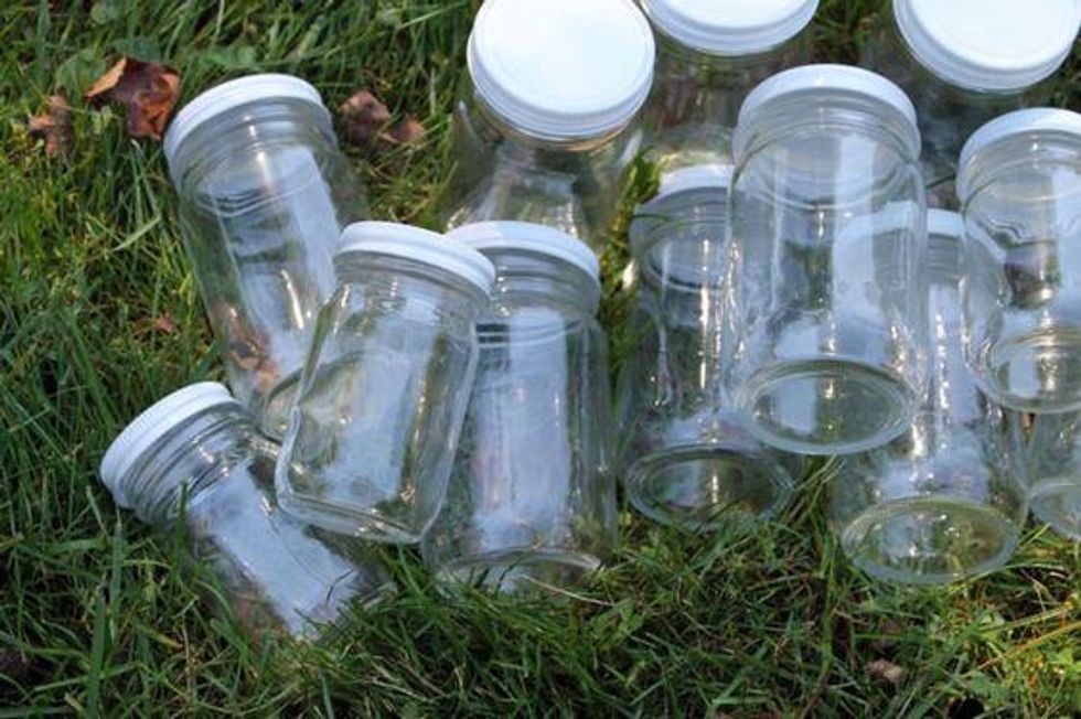 jars with white lids in the grass