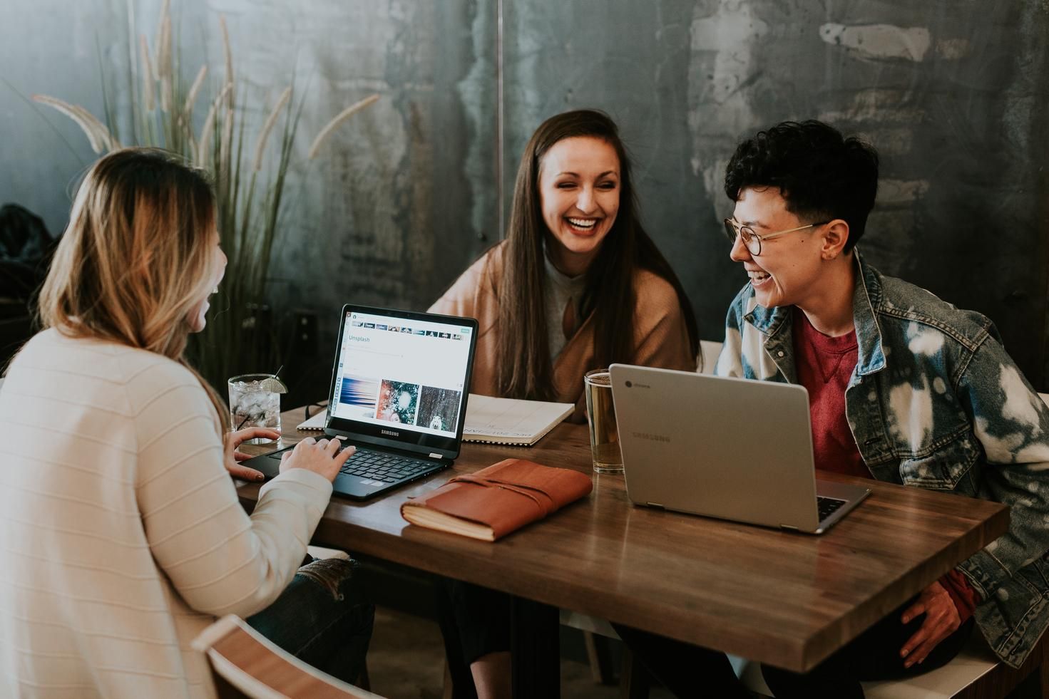 three people on their laptops at a table