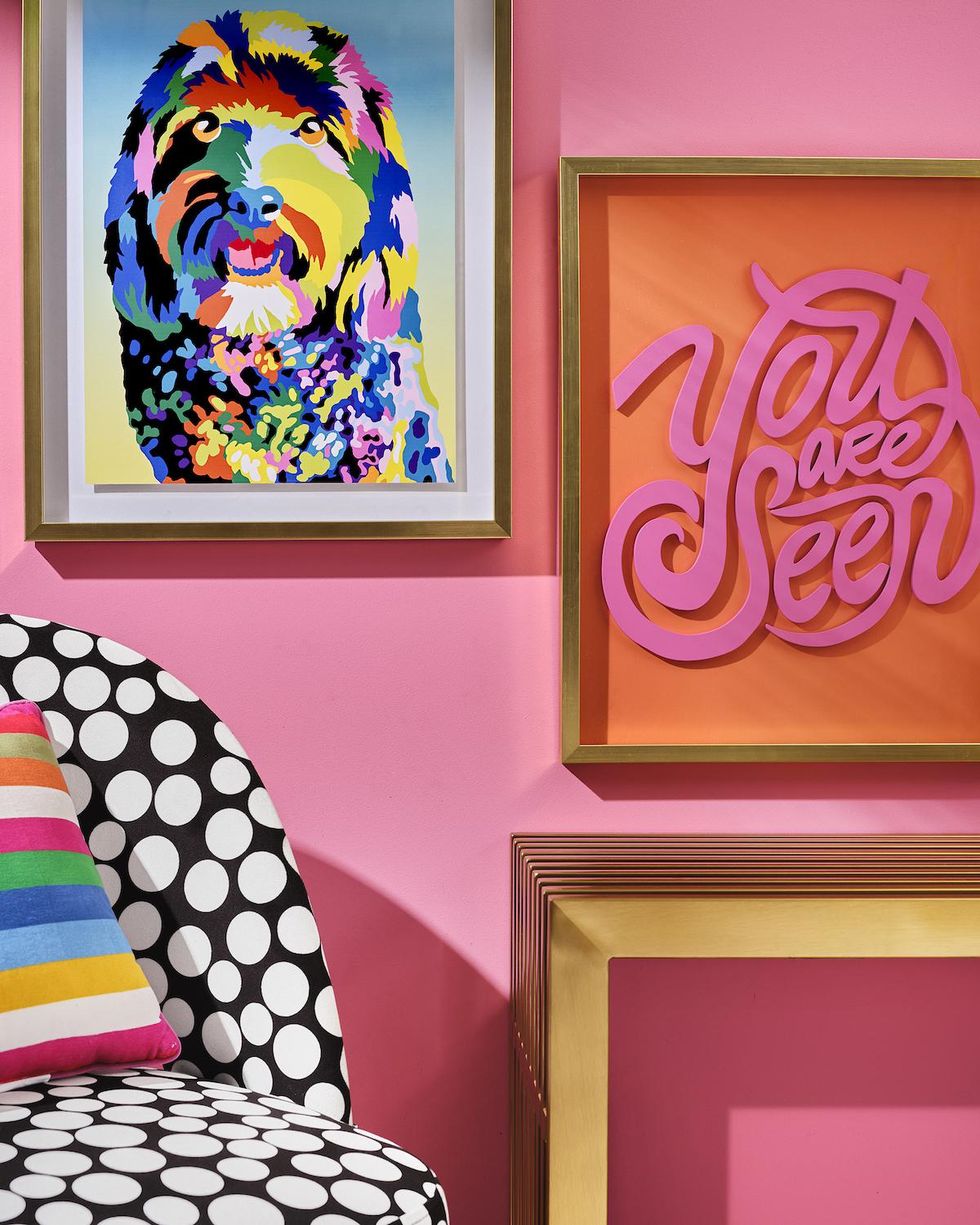 framed wall art with a polka dot chair against a pink wall