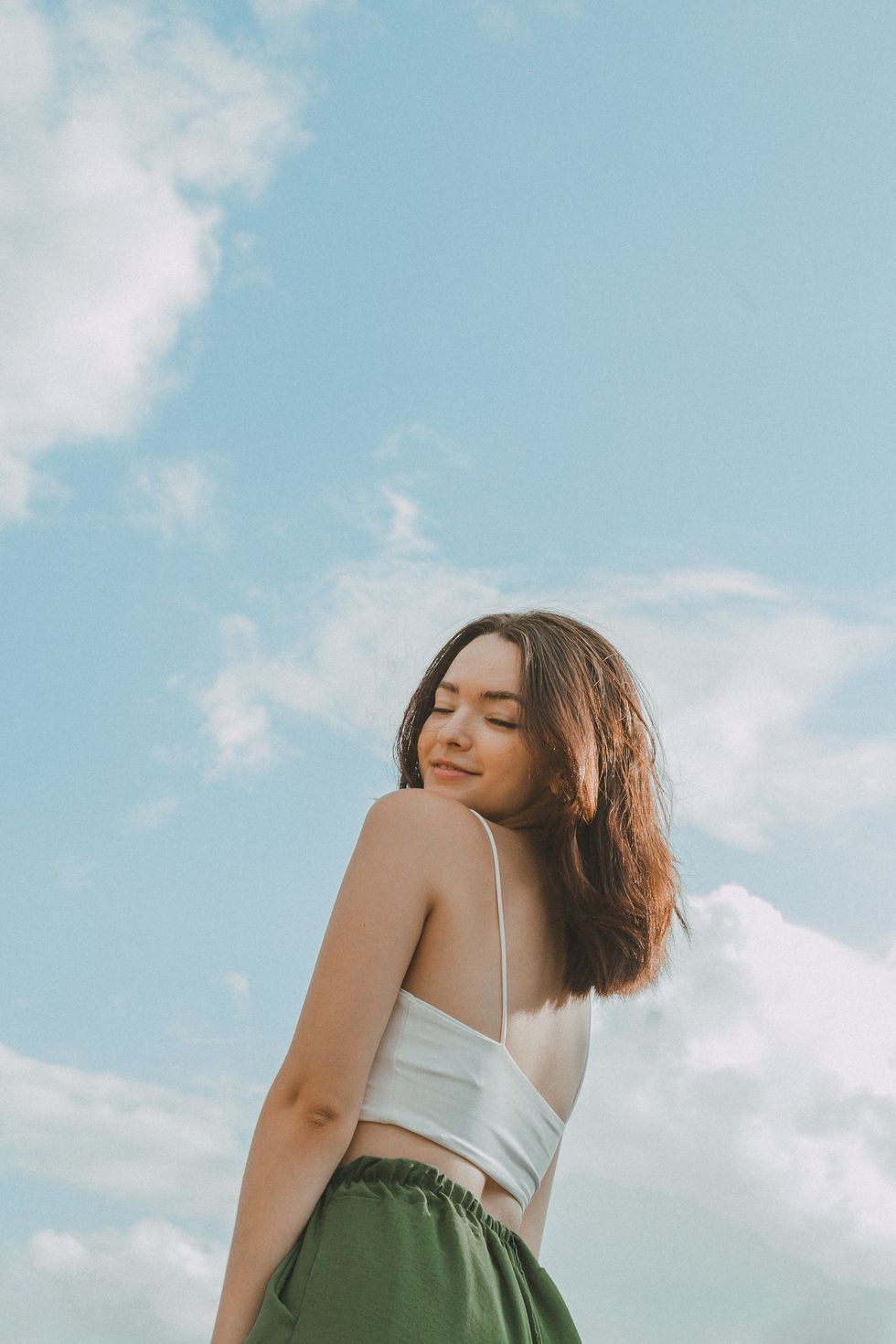 girl against a sky background smiling