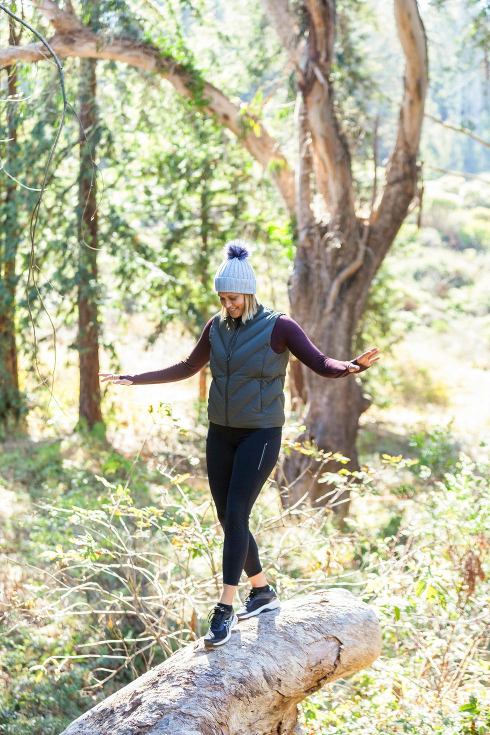 girl going for a hike and standing on top of a rock