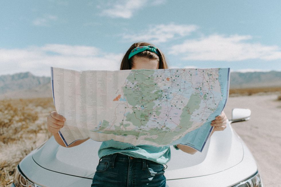 girl holding a map on a road trip