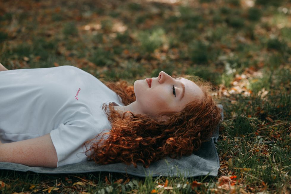 girl laying down on grass with eyes closed