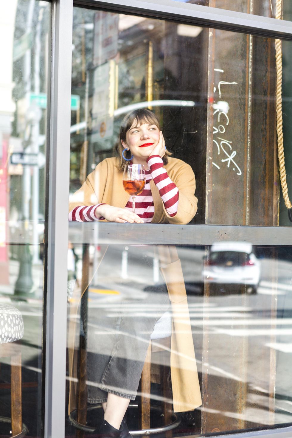 girl sits at a bar and looks out the window