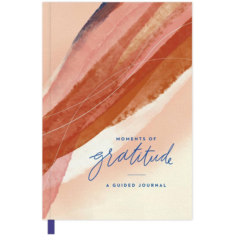 Gratitude journal that says "moments of gratitude: a guided journal."