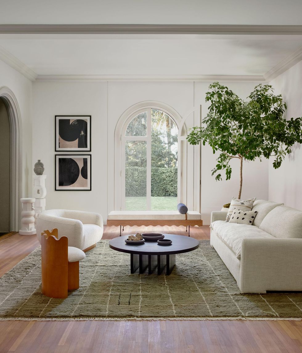 green rug in a large, open room with a white couch and chair