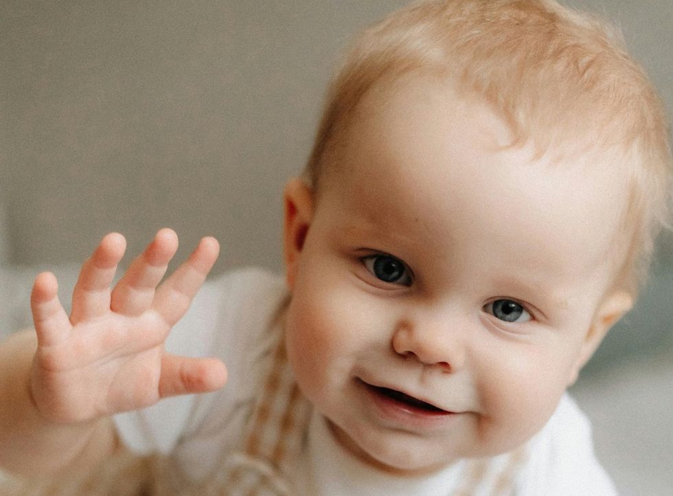 happy baby waving