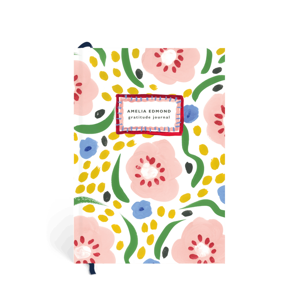 Hardcover gratitude journal with colorful flowers.