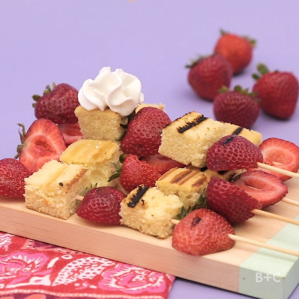 DIY Strawberry kabobs on a cutting board with a red towel on table