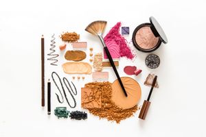 Flat layout of various colors and sizes of beauty products.