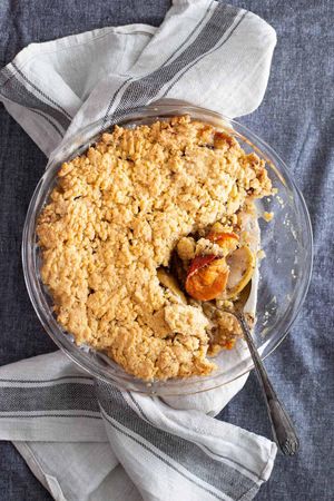 This pie has a spoon lifting up persimmons on a delicious looking crumble on an apple oat pie makes for one of many great persimmon recipes