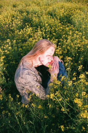 woman in a flower field with closed eyes