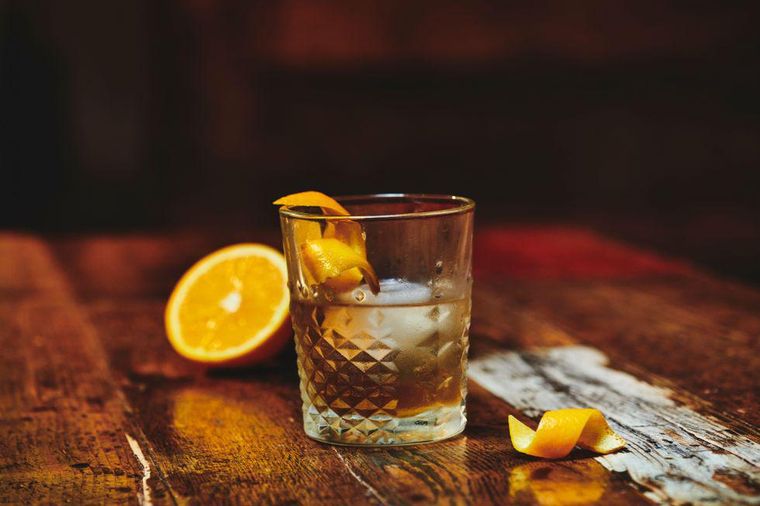 https://www.brit.co/media-library/mezcal-old-fashioned-cocktail-on-a-wood-table-with-orange-peels.jpg?id=26927529&width=760&quality=90