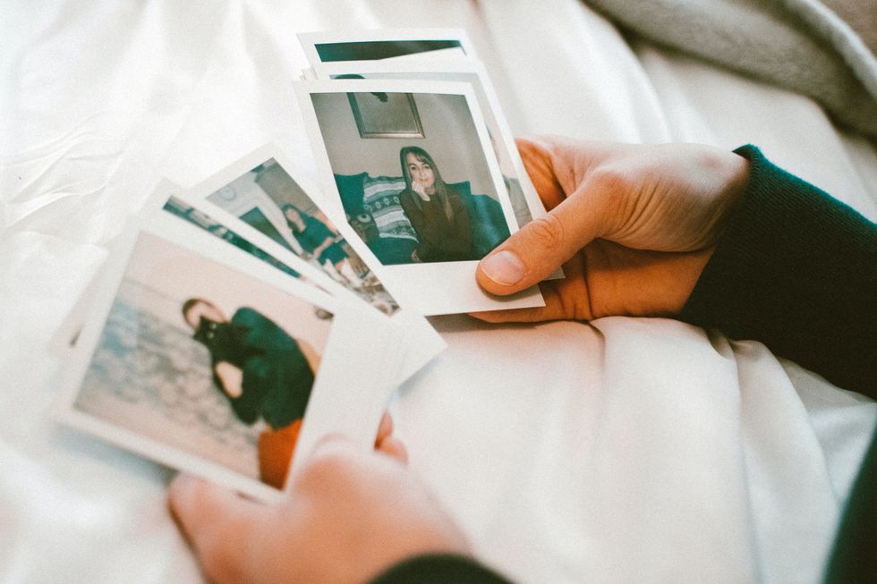 person looking through a stack of polaroid pictures