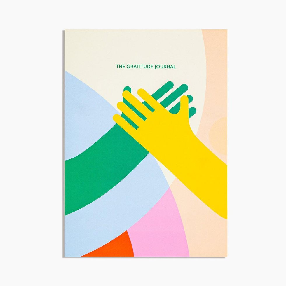 Poketo gratitude journal with colorful hands holding.