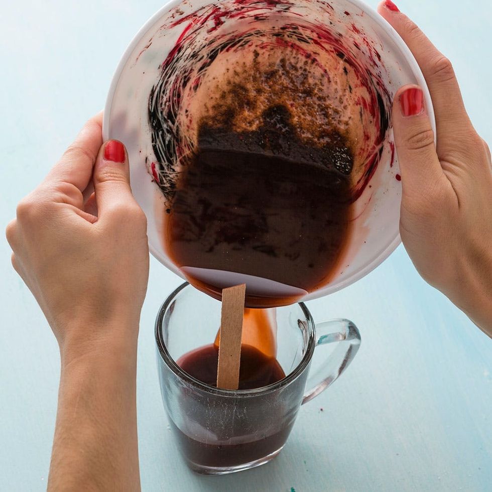 pouring spiced wax into the glass mug