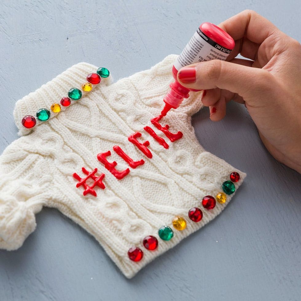 putting puff paint on the Ugly Sweater Ornaments