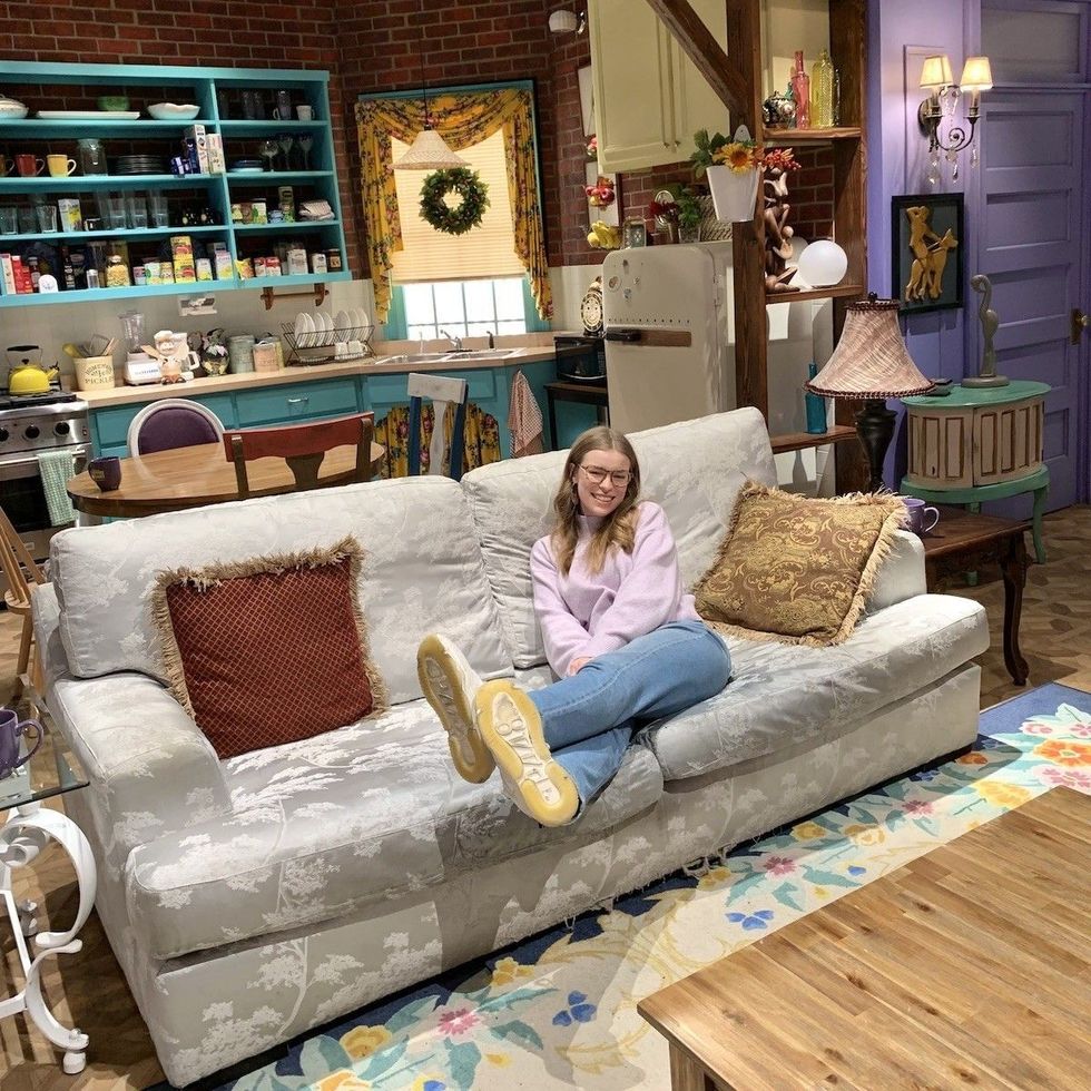 sitting on the couch at the friends experience in monica geller's living room