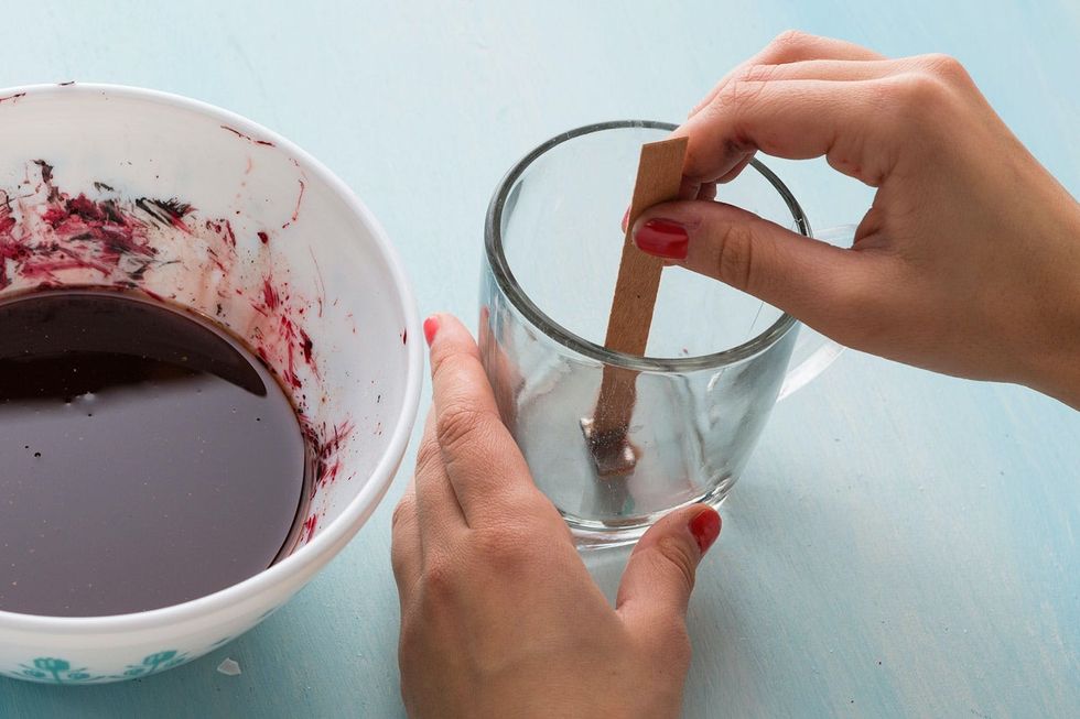 sticking the wooden wick to the bottom of the glass mug Chai Tea candle