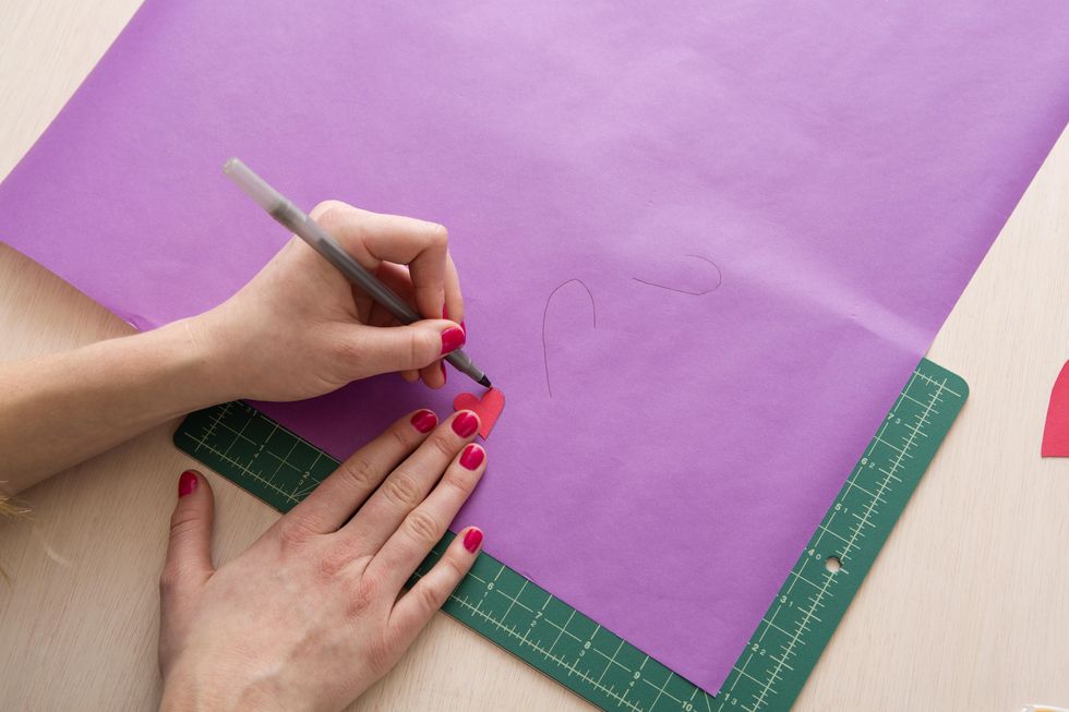 tracing the stencil onto the purple paper