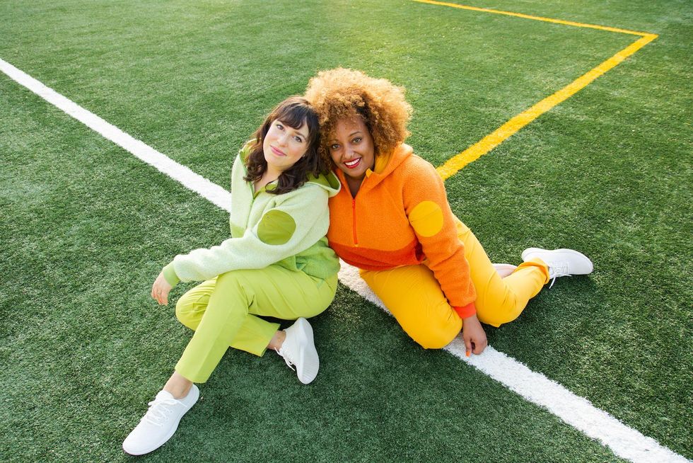 two women sitting on soccer field