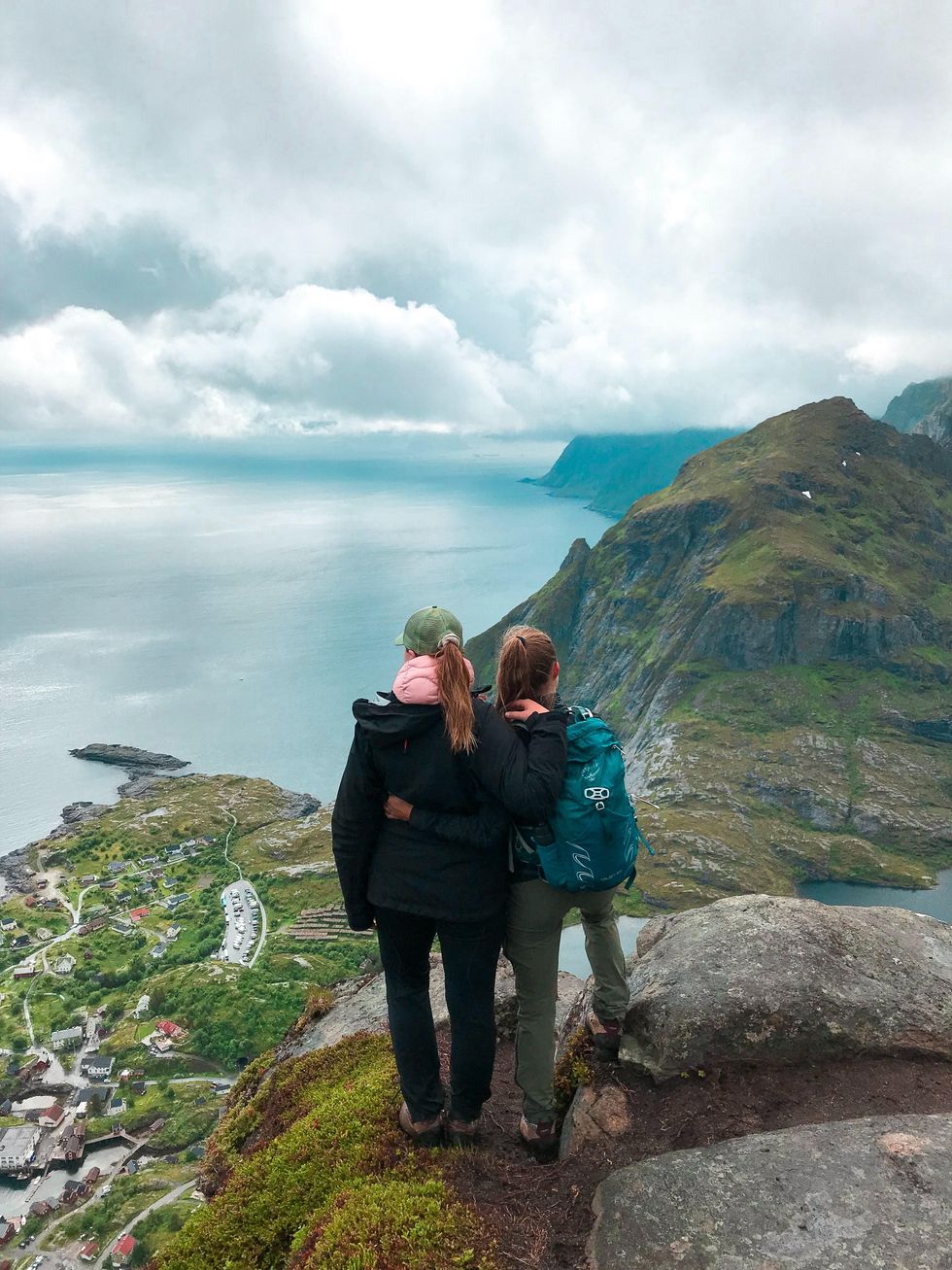 two women standing on a cliff hiking