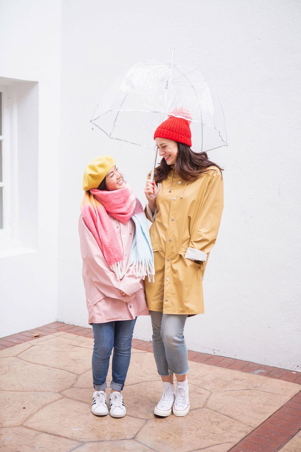 two women standing under an umbrella together