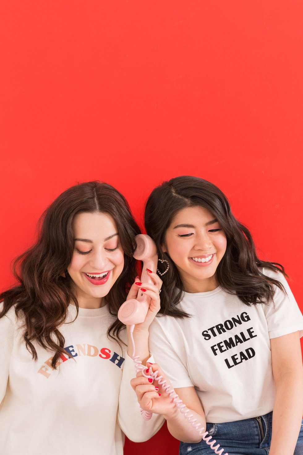 two women talking into a phone